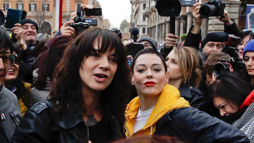 Asia Argento and Rose McGowan surrounded by reporters and cameras