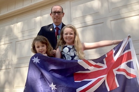 Australian expat Danny O'Neill stands with his family in the US.