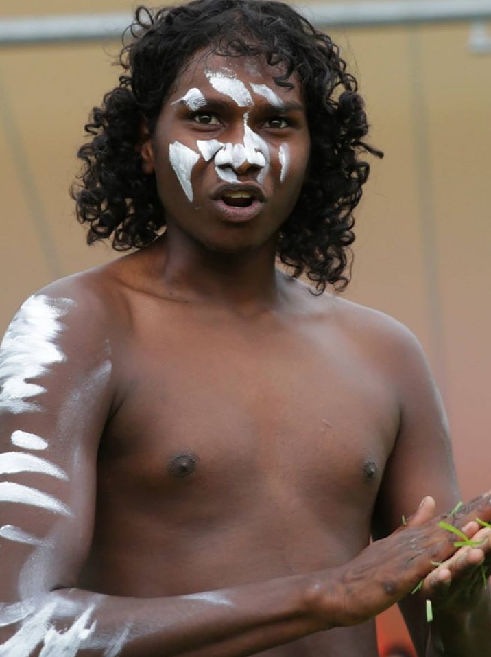 Danzal Baker dances, shirtless, with white painted areas on his face and arms