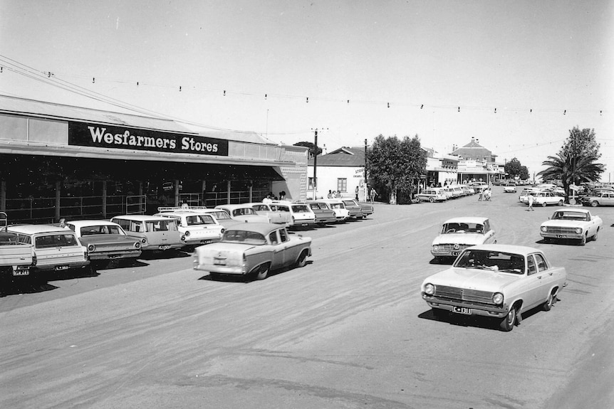 Old-fashioned cars line the streets in front of a Wesfarmers store.