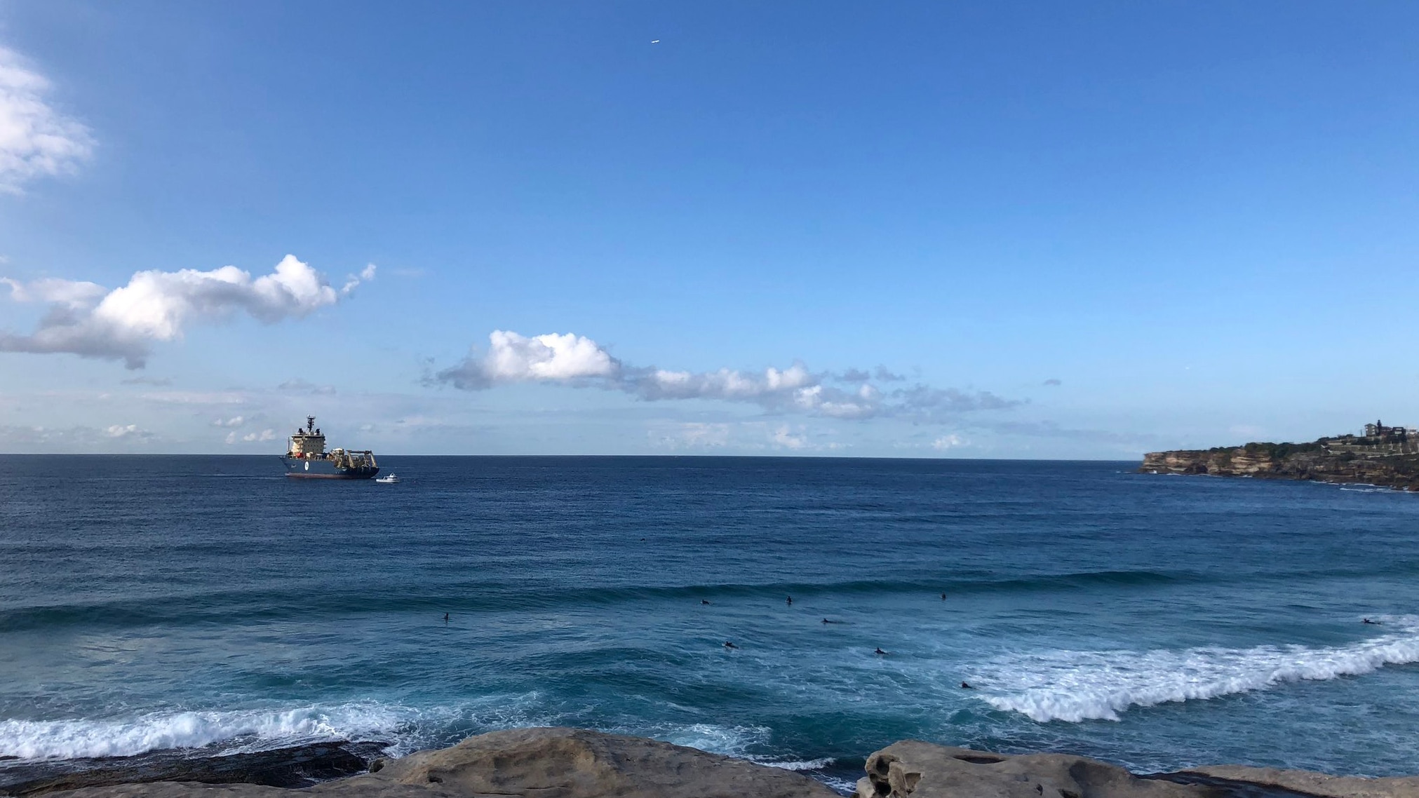 A large cable laying ship is seen quite close to the cliffs at Tamarama. 