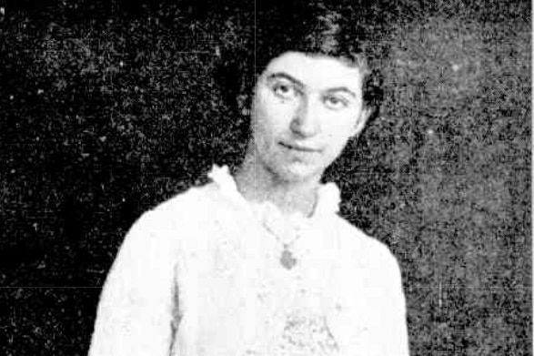 A black and white image of a young woman in a high neck dress in 1913.