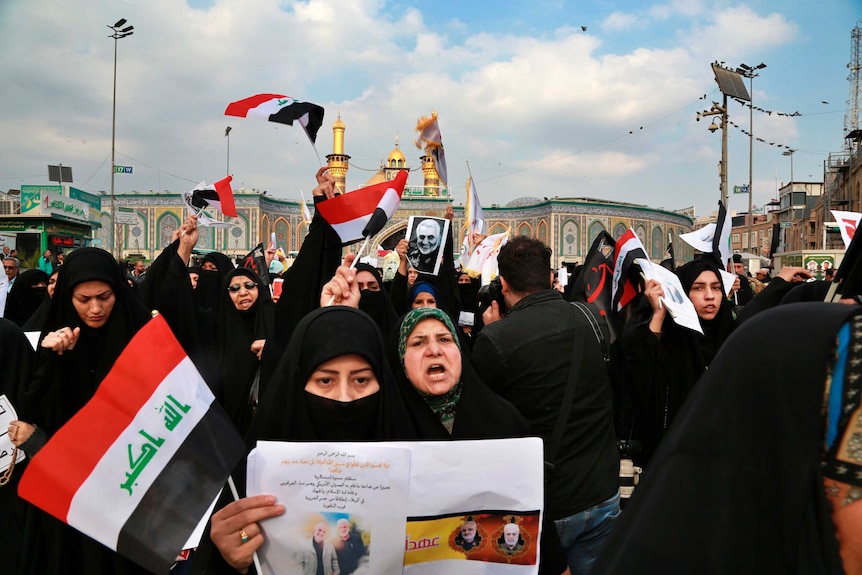 Muslim women protest holding sings and Iraqi flags