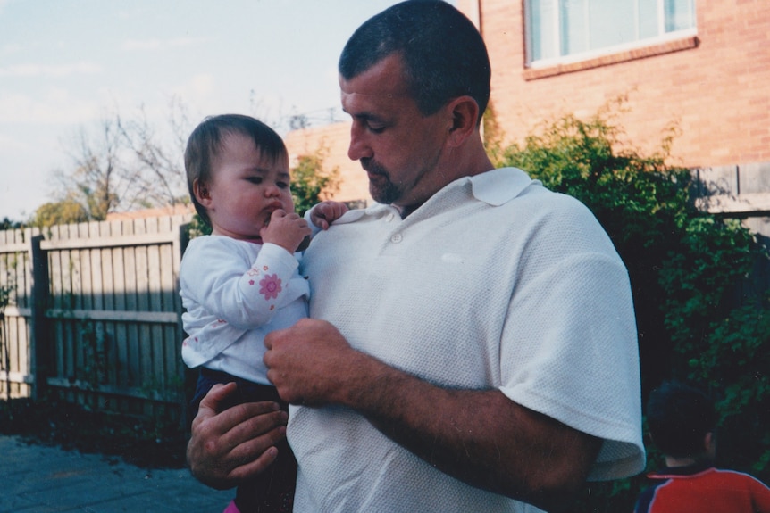 A man holds a toddler.