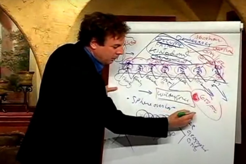 man writing diagram on large paper