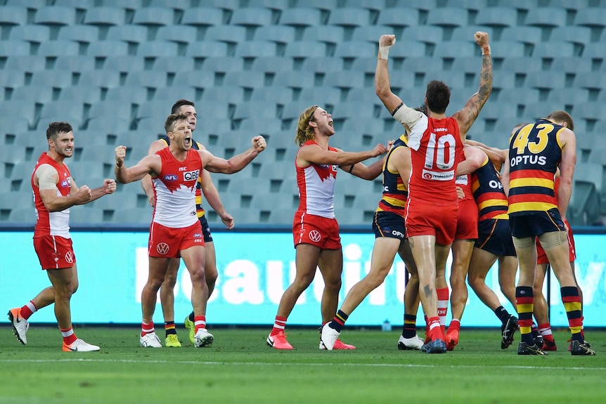 Sydney Swans players celebrate after the full-time siren against Adelaide Crows in the AFL.