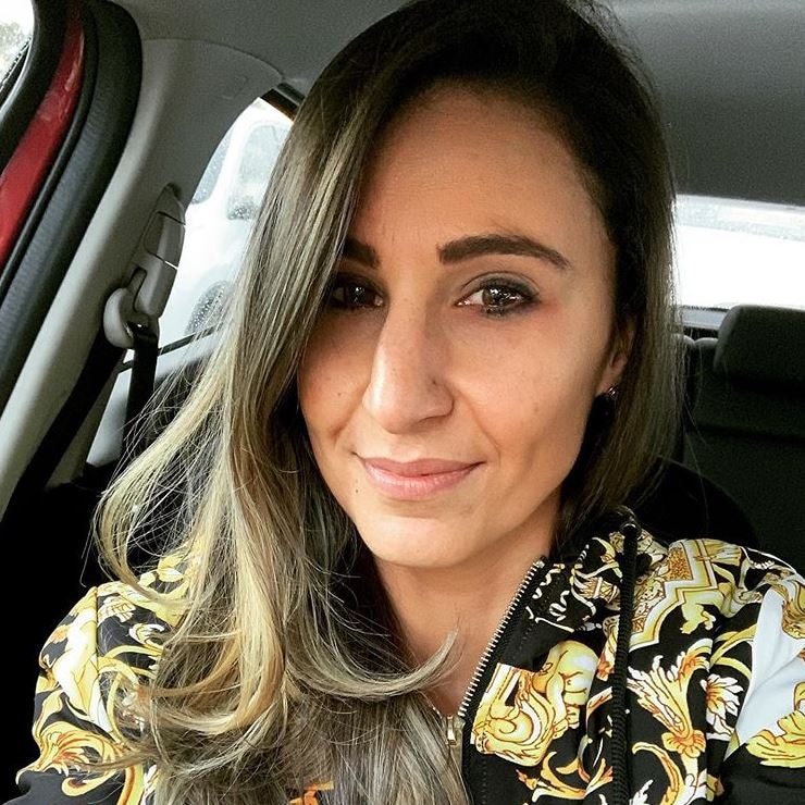 Amamnda Micallef in her car wearing a black and gold jacket.