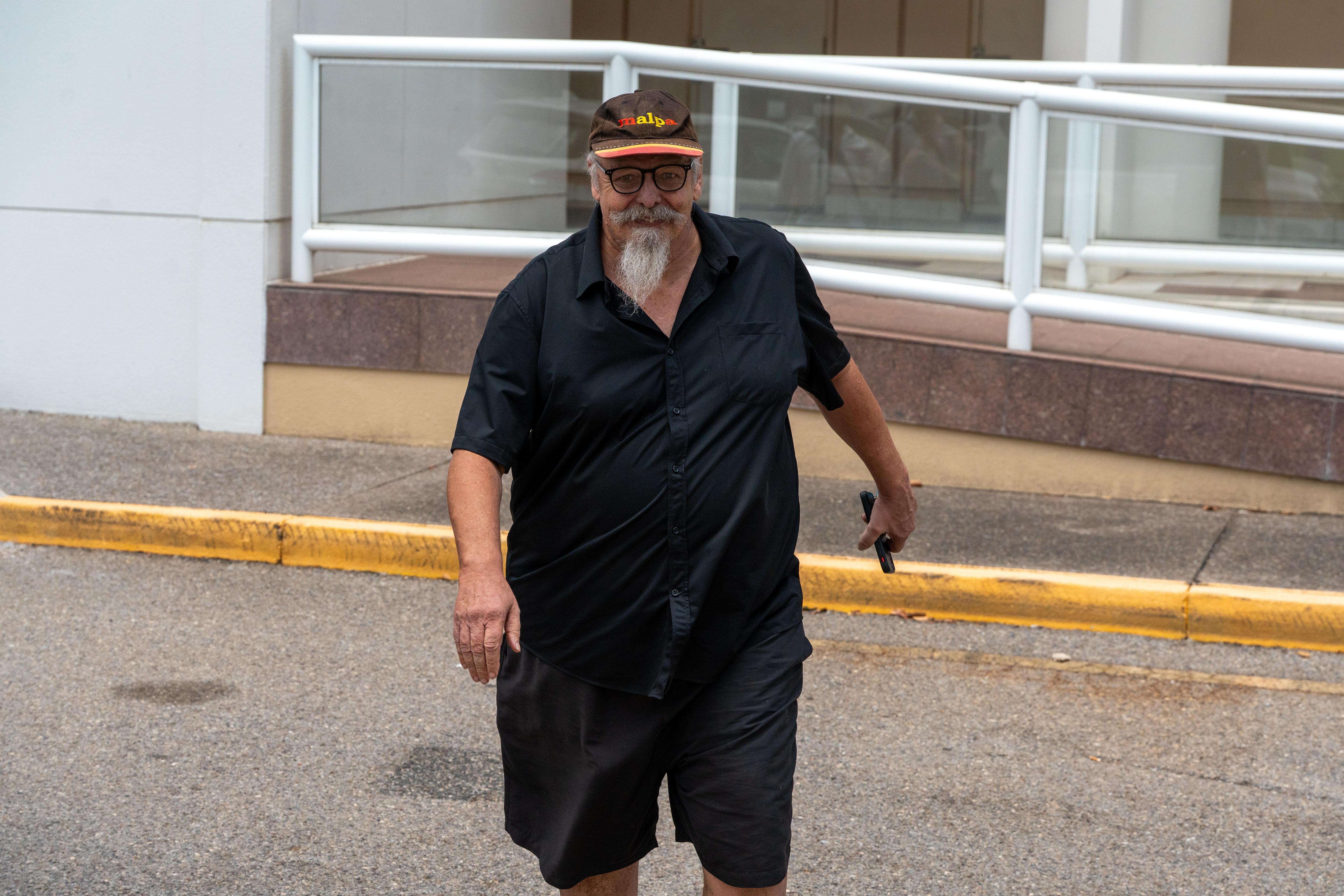 Um homem de chapéu está saindo do tribunal.