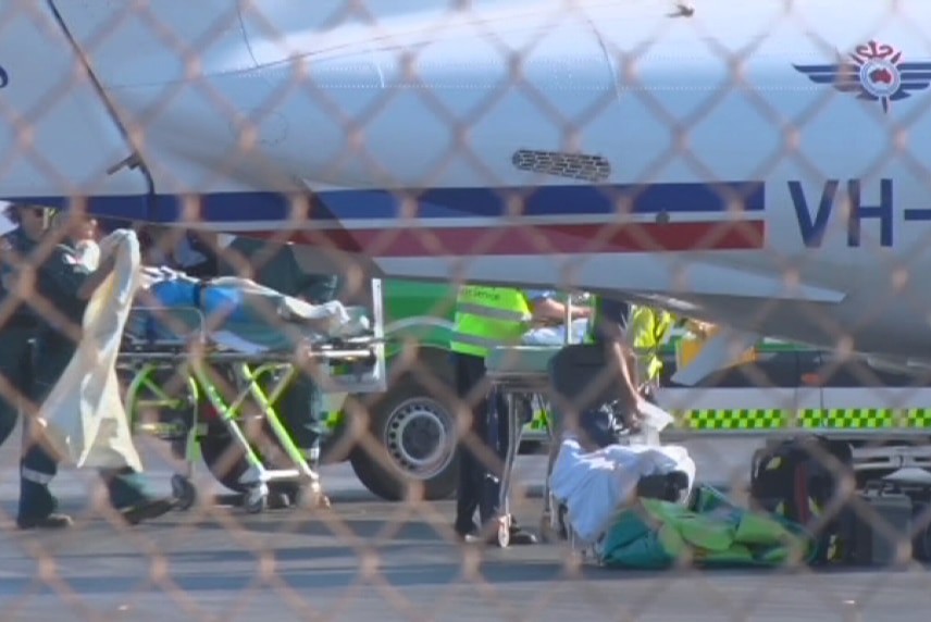 The father is taken by stretcher to a plane in Karratha