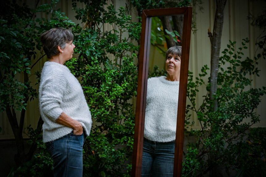 Rebecca Smyth looks at herself in a full length mirror.
