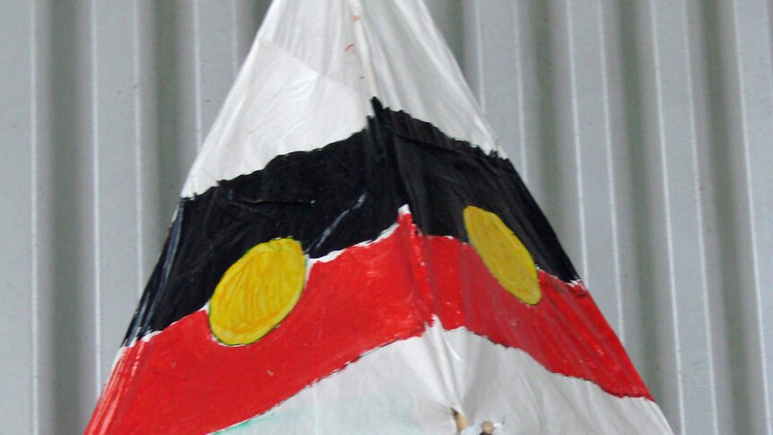 Pyramid-shaped lantern with Aboriginal flag painted on it.