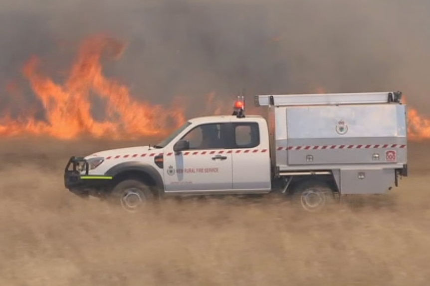 An RFS vehicle travels along the fire front.