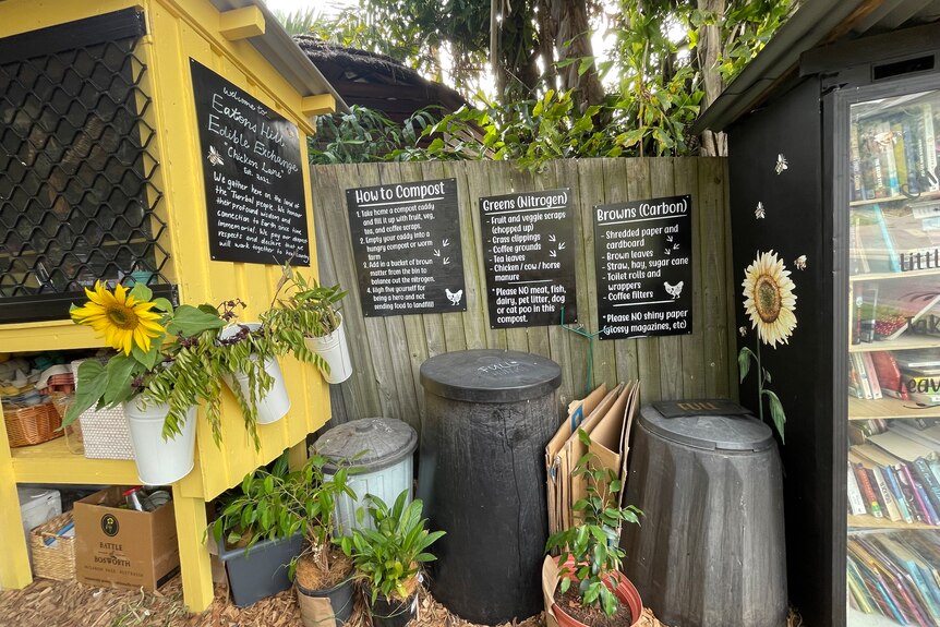Community library, compost bins, plants and a yellow chick hutch.