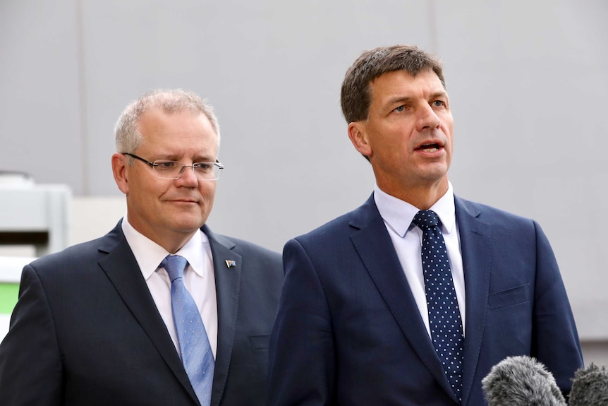 Angus Taylor speaks to media as PM Scott Morrison looks on from behind