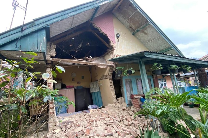 Photo of a destroyed house particularly the walls at the front and the second floor