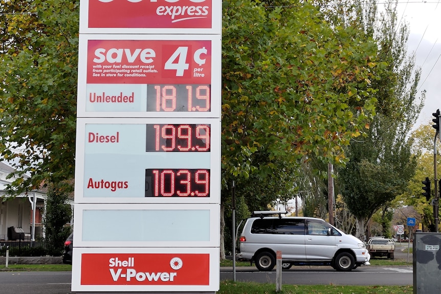 A sign with fuel prices on it outside a service station.