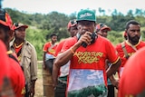 A man in a red Adventure Kokoda t-shirt speaking into a walkie talkie