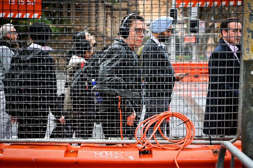 A man behind a grill in the city.