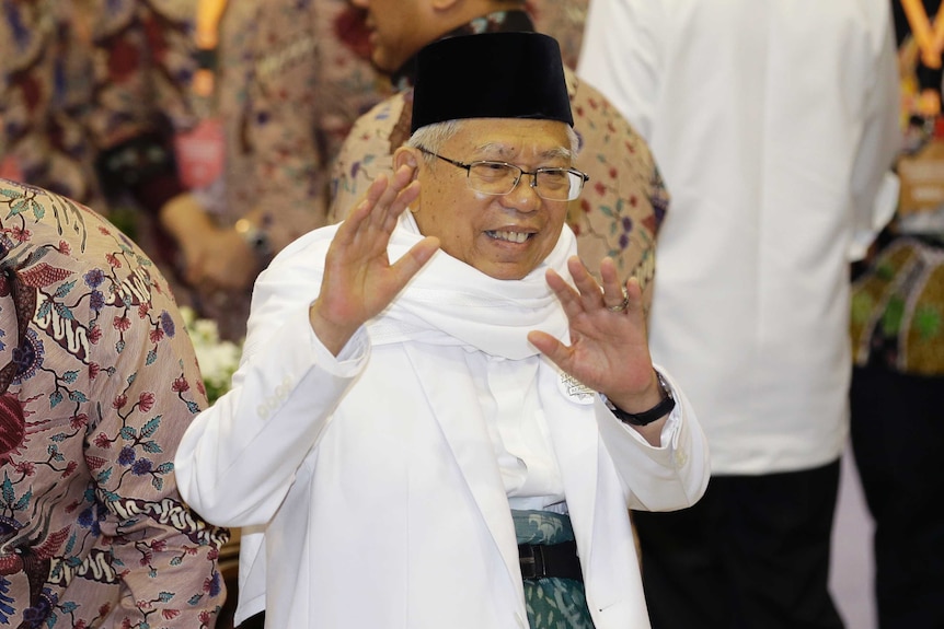 Indonesian vice-presidential candidate Ma'ruf Amin waves to journalists during formal registration as candidate