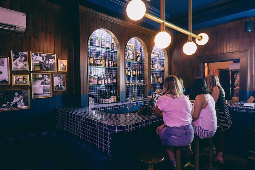 Three women sit at the bar of a new gastropub in Adelaide called Hotel Longtime.