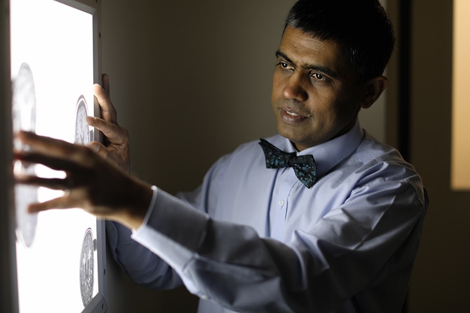 A man looking at brain scan images