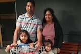 The Murugappan family stands outside a supermarket with a trolley