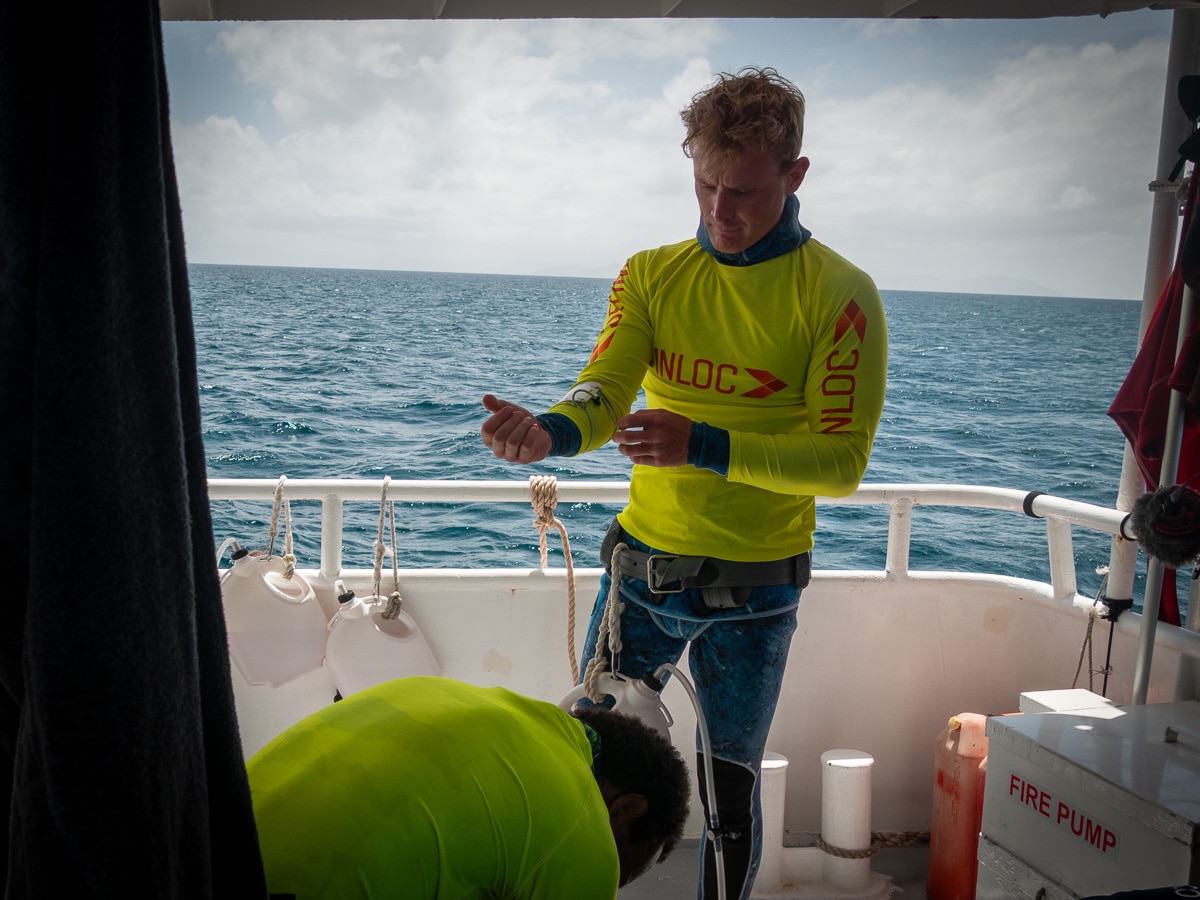 Un hombre con un chaleco de alta visibilidad para bucear en un barco en el mar.