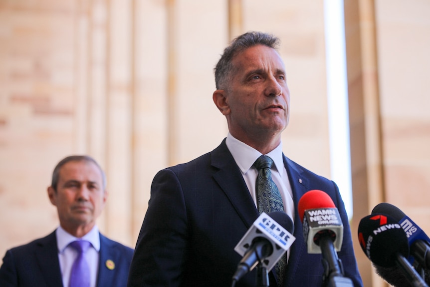 WA Corrective Services Minister Paul Papalia speaking at a media conference with Premier Roger Cook behind him.