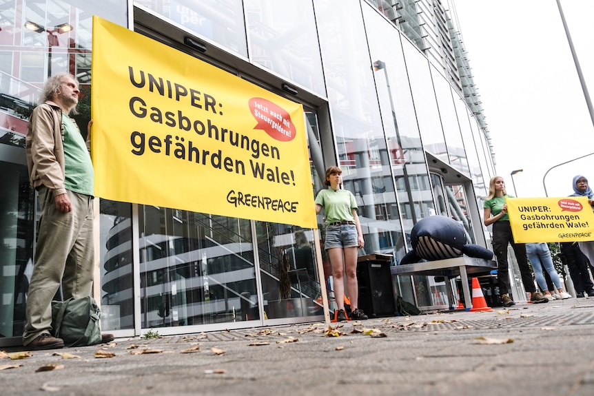 Greenpeace Germany protesters and an inflatable whale outside Uniper's headquarters