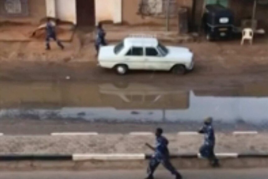 Police are seen running through the streets in a grainy image.