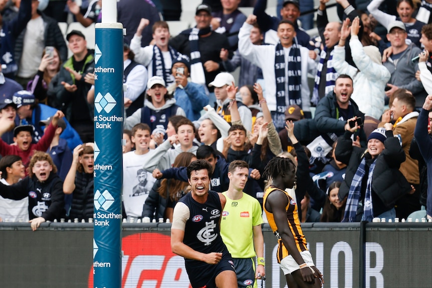 Jack Silvagni runs off smiling while Carlton fans behind him go nuts