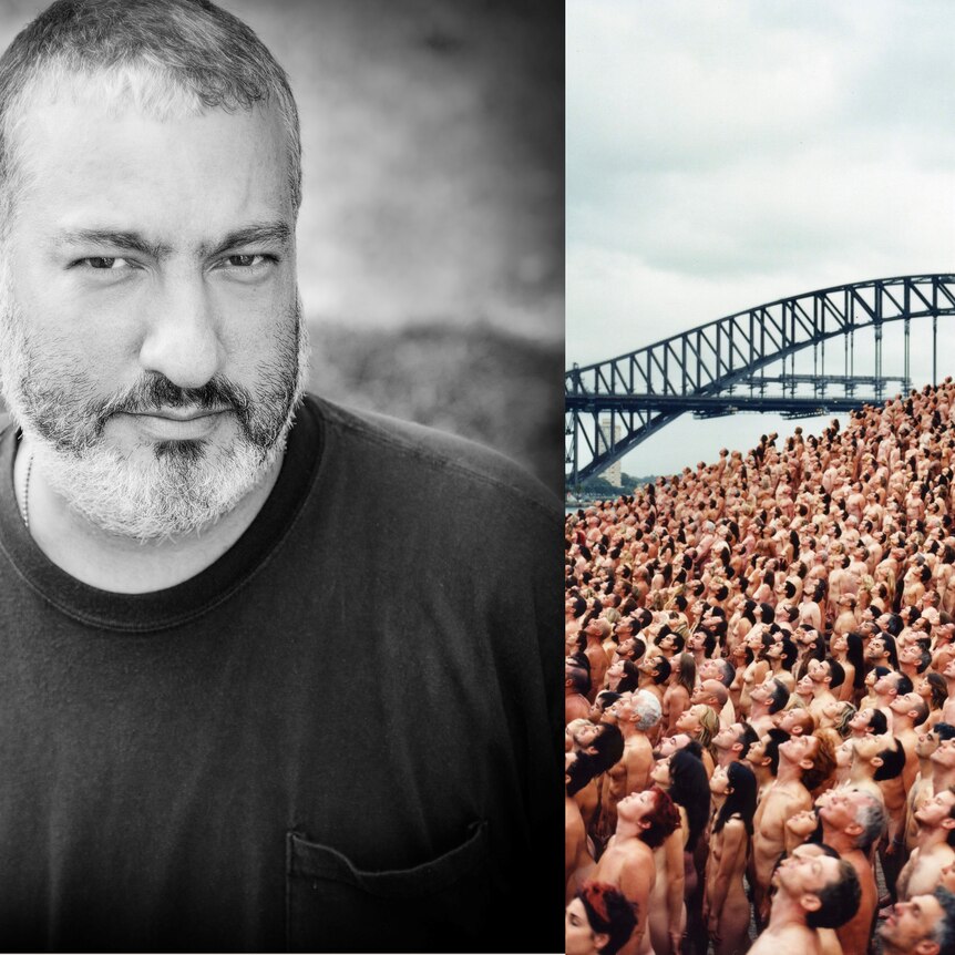 Composite image - photo of Spencer Tunick looking serious and thousands of naked people  looking up to the sky 