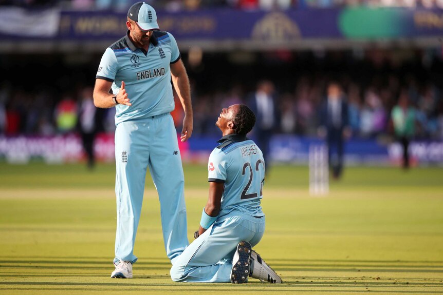 Jofra Archer kneels as Liam Plunkett looks to shake his hand after winning the Cricket World Cup