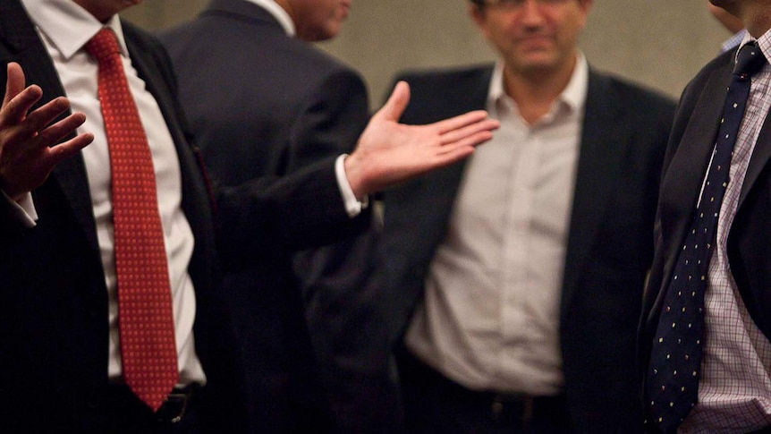 Men in suits talk outside a company annual general meeting