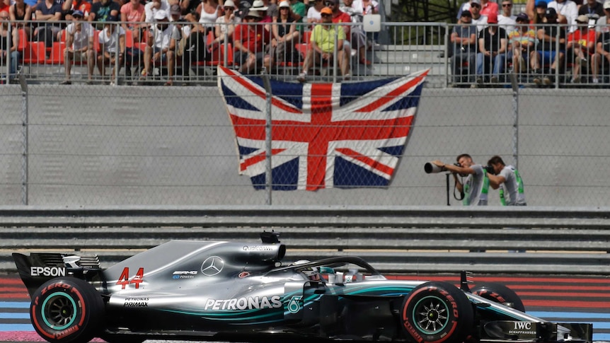 Lewis Hamilton drives past the English flag