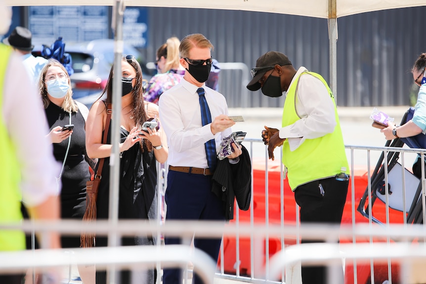 A man shows a security guard his license.