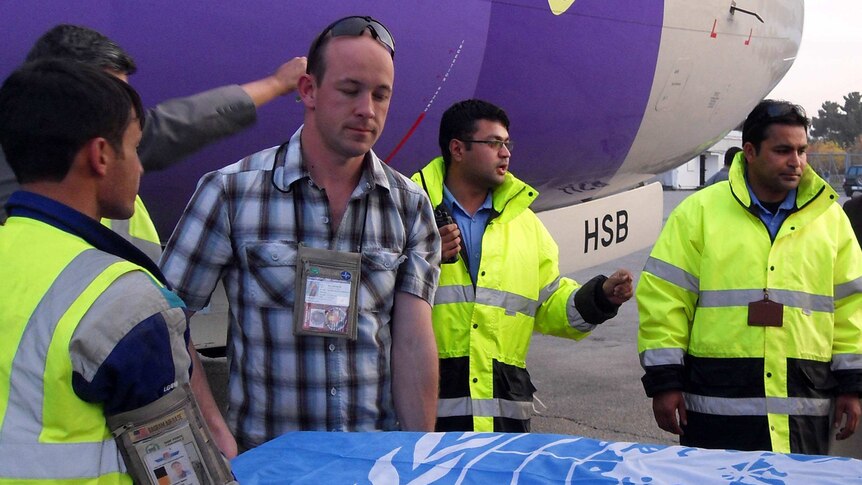 UN paramedic Benjamin Nelson stands by the coffin of a colleague killed in the Taliban attack.