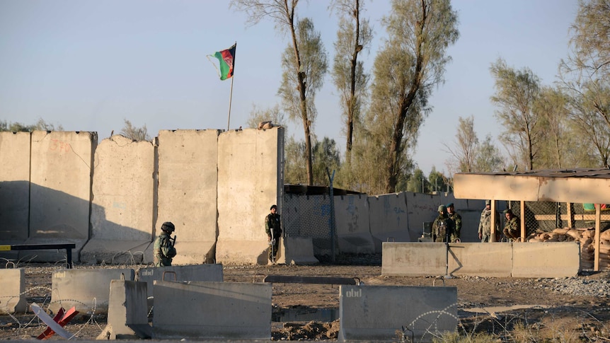 Afghan security personnel stand guard near the airport complex.