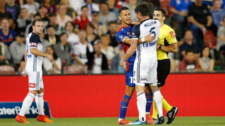 Daniel Georgievski of the Newcastle Jets and Mark Milligan of The Melbourne Victory in a scuffle during an A-League match
