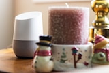 A Google Home next to Christmas decorations in a home.