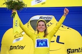Annemiek Van Vleuten of the Netherlands is pictured in the yellow jersey, raising her arms aloft, after winning the Tour