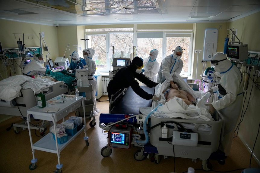 Medics look after patients in a hospital room.