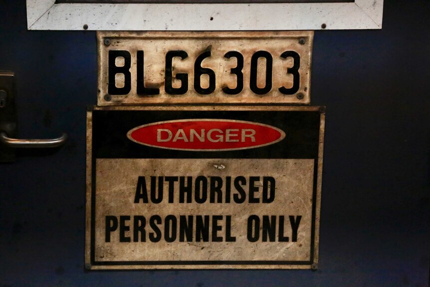 A dirty sign which reads "Danger, authorised personnel only"