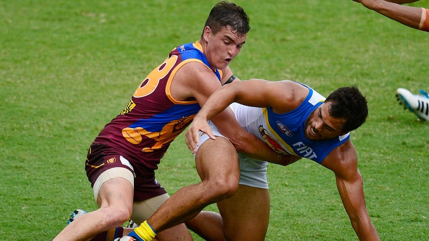 Brisbane's Tom Rockliff tackles Gold Coast's Karmichael Hunt