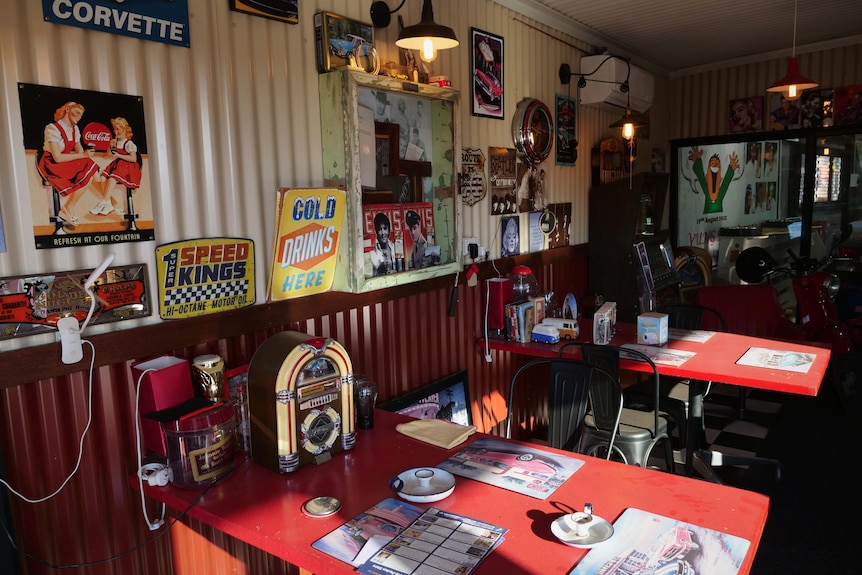 The interior of a vintage-looking 1950s diner with memorabilia on the table and walls