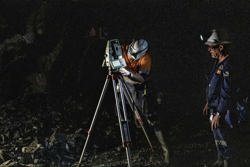 A surveyor working underground at a gold mine.