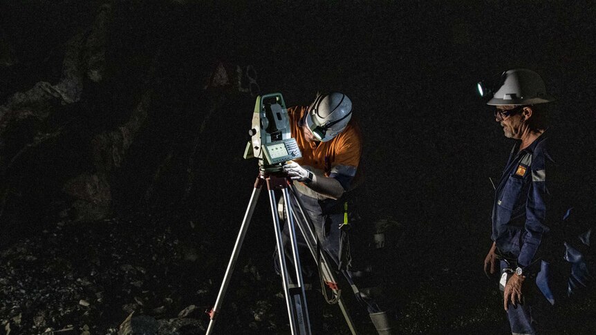 A surveyor working underground at a gold mine.