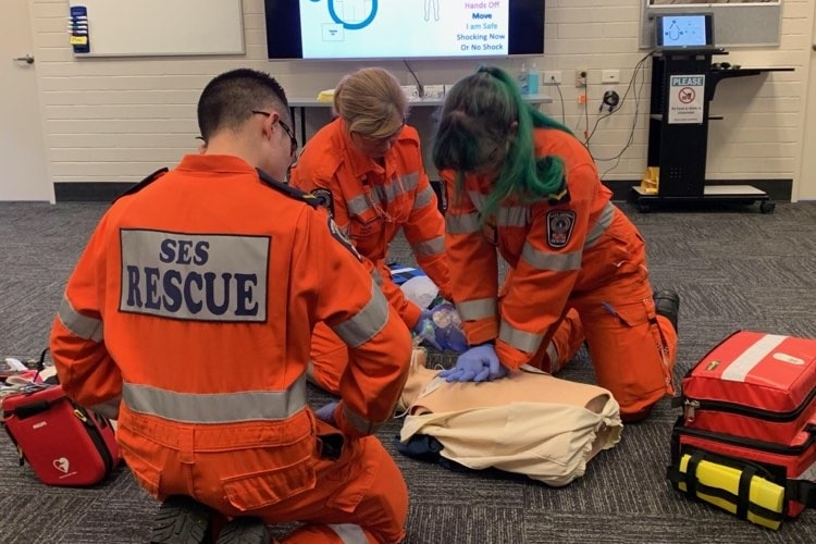 Three SES volunteers wearing orange overalls