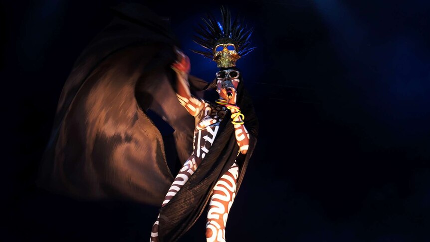 Grace Jones wear a tribal-like outfit on stage.