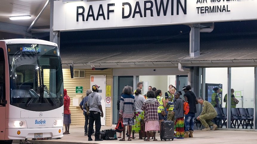 A group of people stand outside the terminal